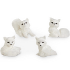 Four white faux-fur fox figurines shaped like foxes in different sitting poses, photographed on a clean white background.