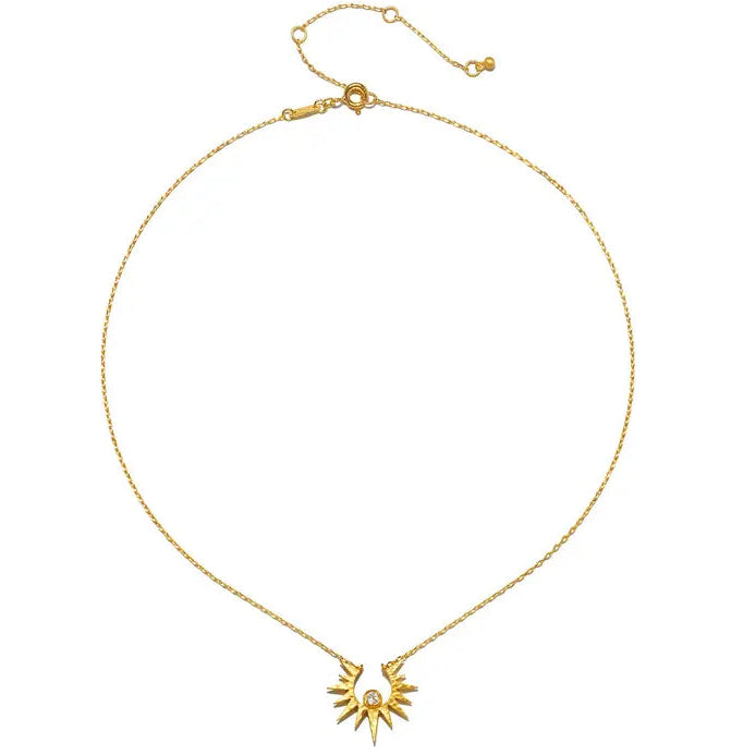 A delicate gold chain necklace featuring a small sunburst pendant with a central clear gemstone, displayed on a clean white background.