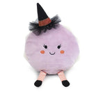 A cute, round lavender macaron plush toy styled with a witch hat with a smiling face, wearing a black witch hat with a black tulle sash and orange glitter band, and striped pink and white legs.