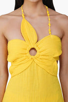 Yellow halter dress with a unique design on a white background
