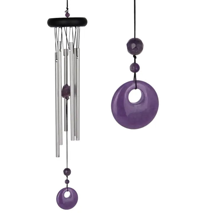 Decorative wind chime with purple and silver elements on a white background