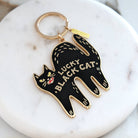 Black cat keychain with 'Lucky Black Cat' text on a marble surface