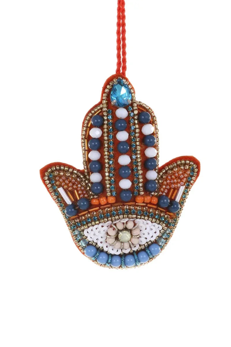 Decorative Hamsa hand ornament with beads on a white background