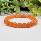 Calcite Orange 6mm Smooth Bead Stretch Bracelet on white background