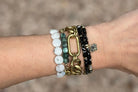 Black Spinel Cubes on Sealed Brass Curb Chain Bracelet with Black Lotus Charm on Wrist