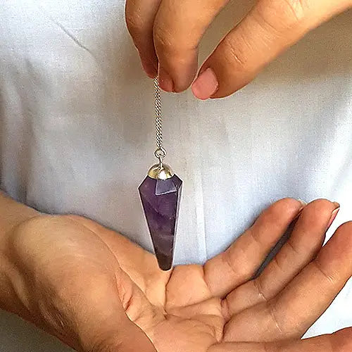 Holding amethyst pendulum