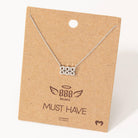 Silver necklace on a brown cardboard card with branding
