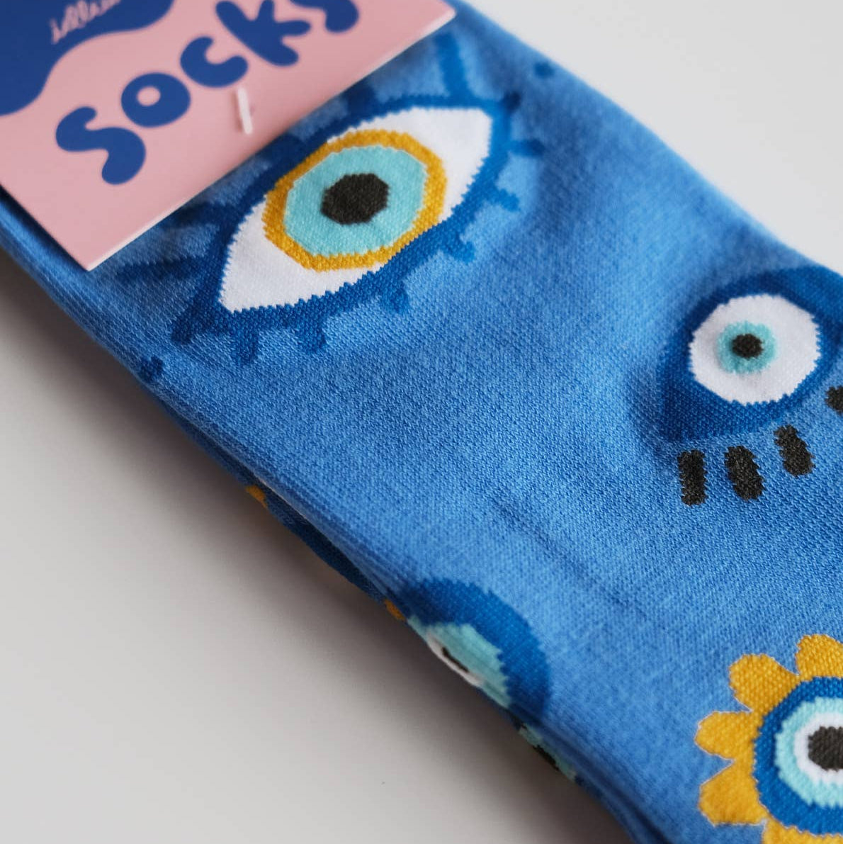 Pack of blue socks with monster design on a light gray background