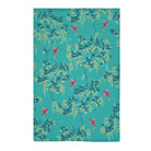 A tea towel featuring a repeating pattern of teal, green, and yellow foliage with small pink birds on a turquoise background.