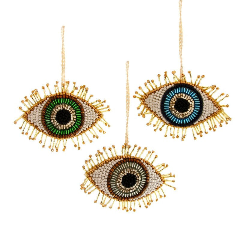 Three decorative evil eye-shaped ornaments with bead details on a white background