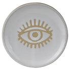 Round ceramic dish with a gold eye design on a white background