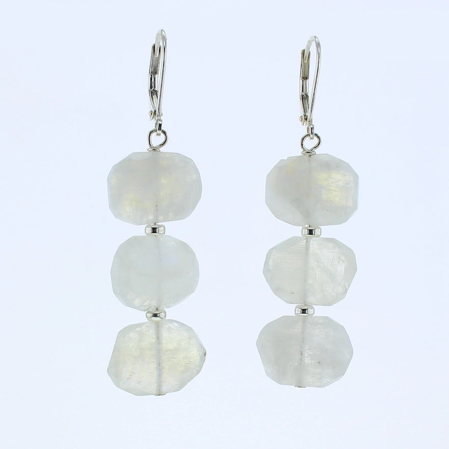 A pair of silver leverback drop earrings featuring three stacked, moonstone gemstone beads on each earring, set against a plain light blue background.