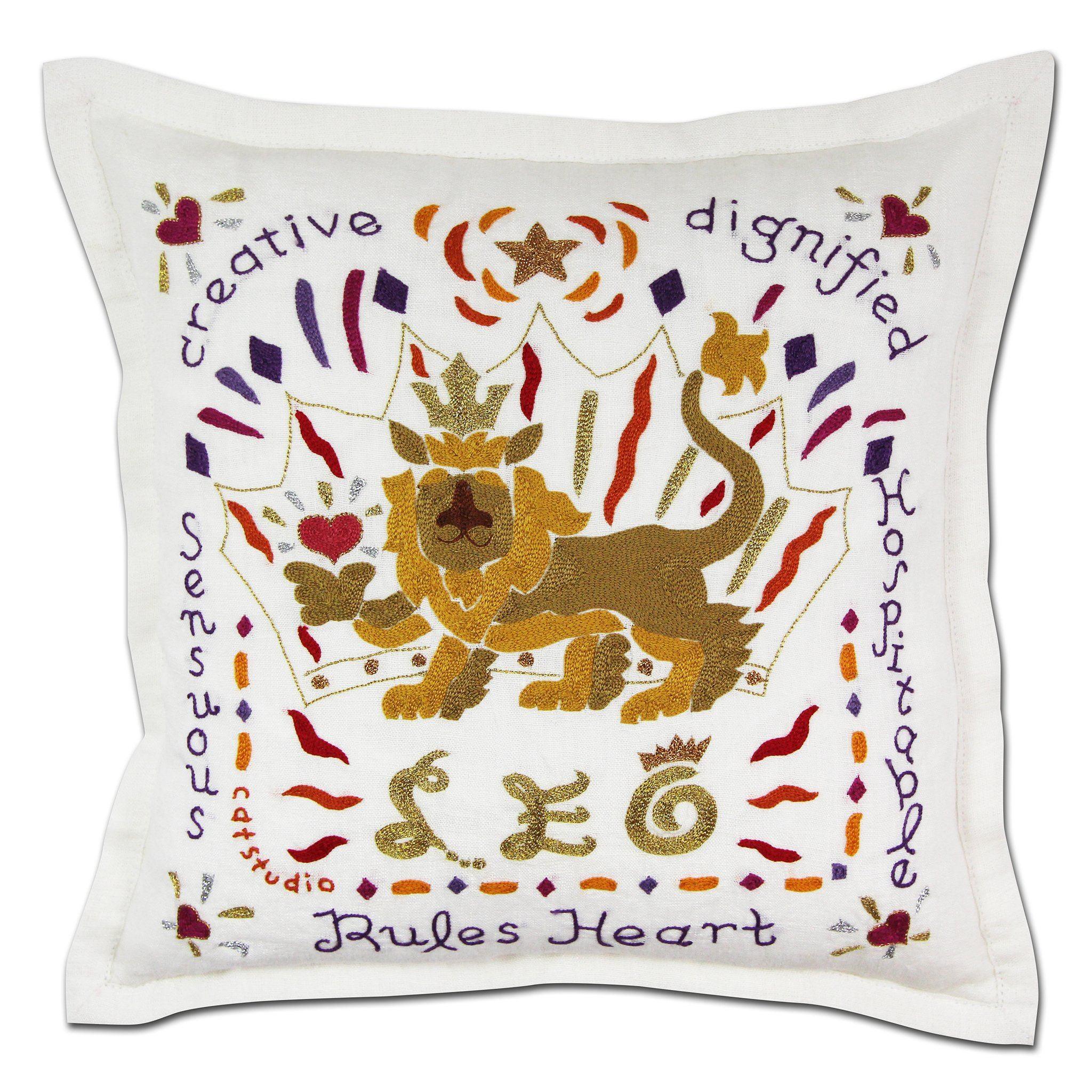 Decorative pillow with embroidered lion design and text on a white background