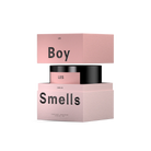 Pink cosmetic product packaging with 'Boy' and 'Smells' text on a white background