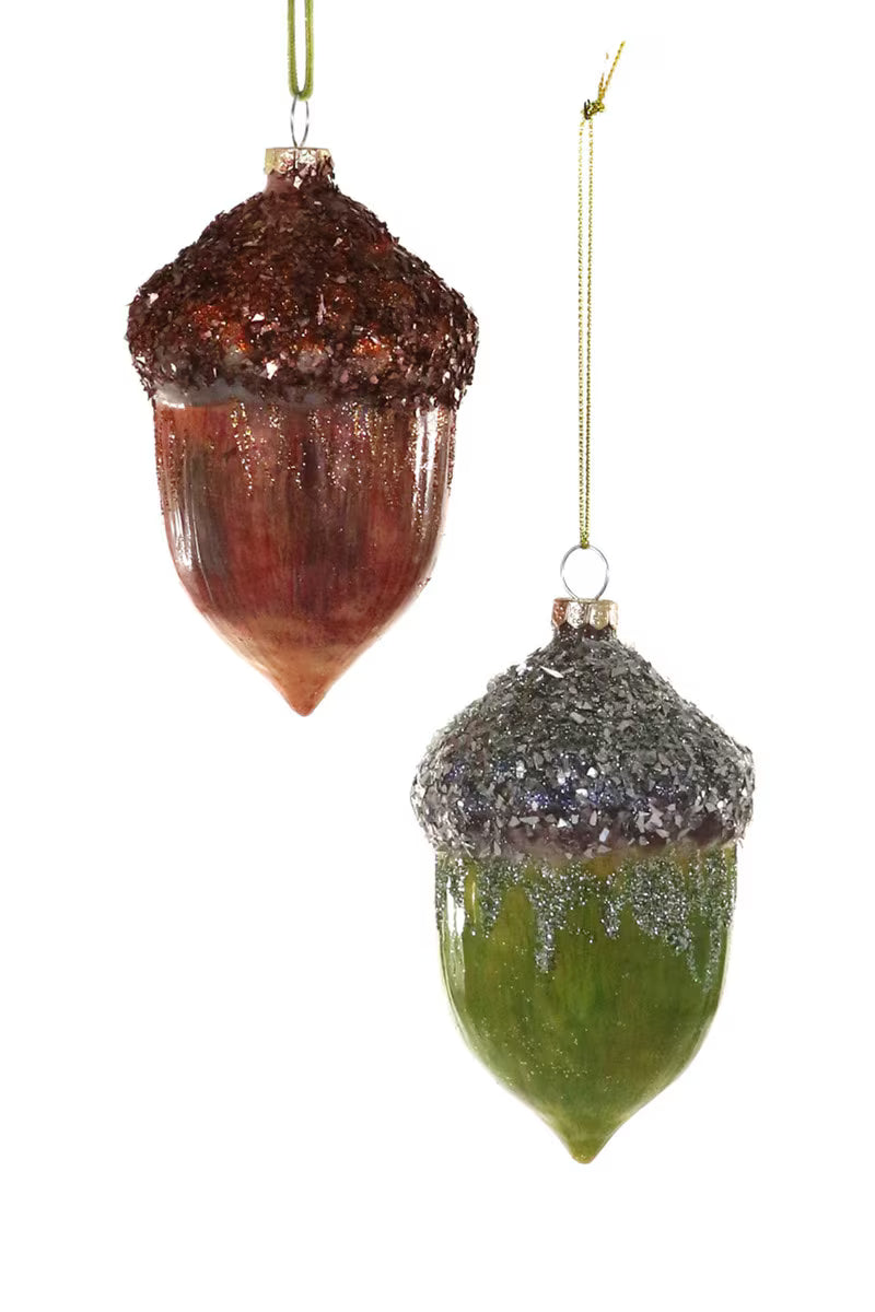Two glass acorn ornaments, one brown and one green, on a white background.