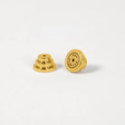 Two small gold metal earbud tips, one showing the layered stem side and the other showing the flat circular end 