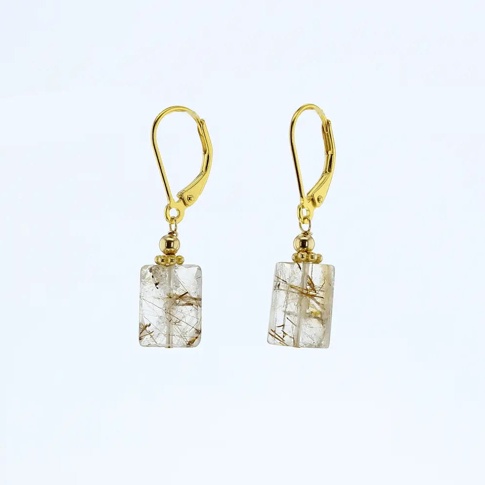 A pair of gold leverback drop earrings featuring rectangular clear rutilated quartz crystals with visible golden needle-like inclusions, set against a plain white background.