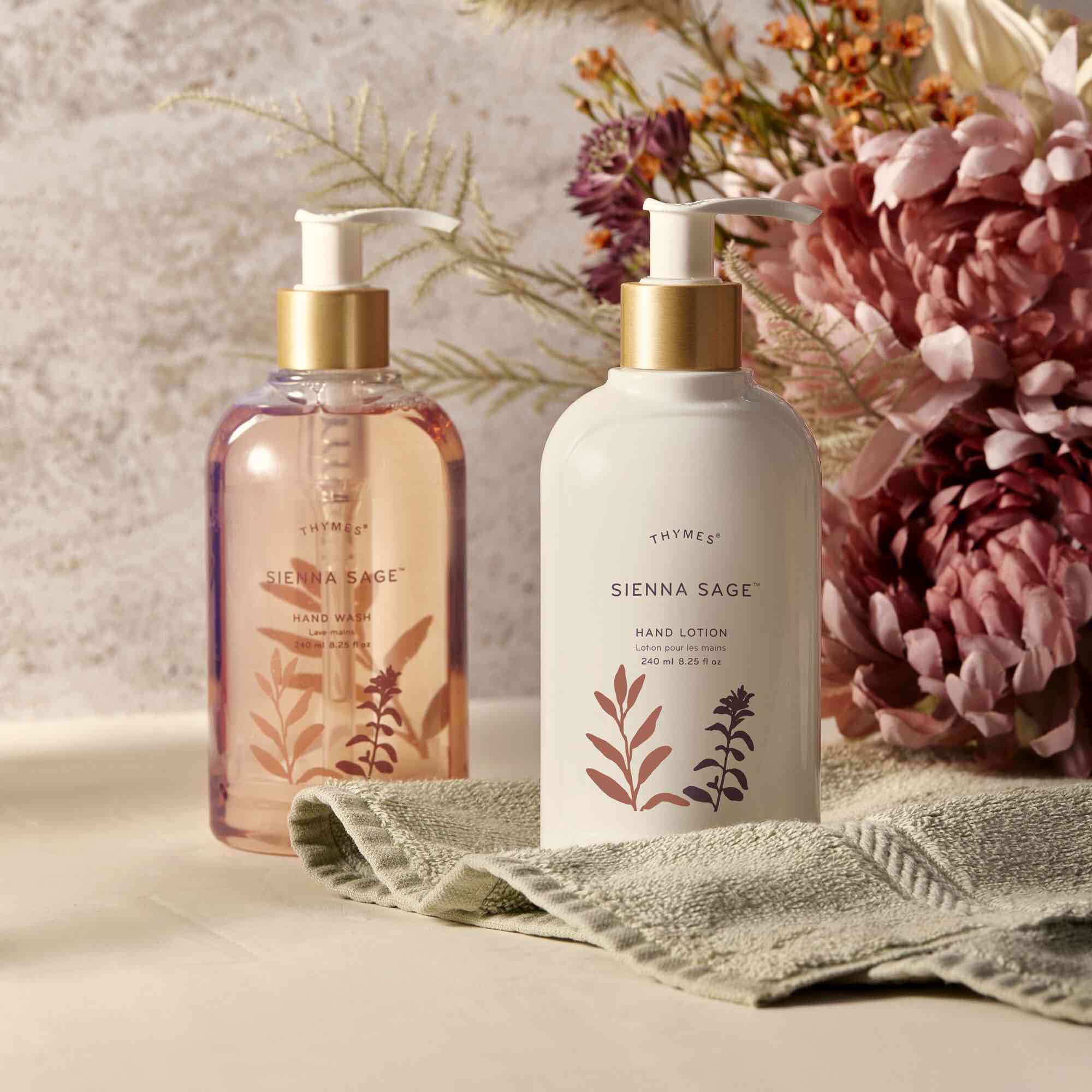 Sienna Sage Hand Lotion in a decorative setting with flowers and a bathroom towel