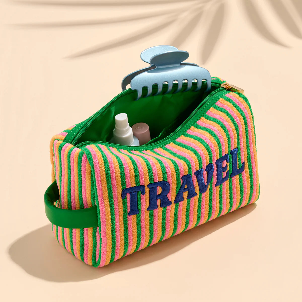 Striped travel pouch with 'TRAVEL' text on a beige background