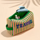 Striped travel pouch with 'TRAVEL' text on a beige background