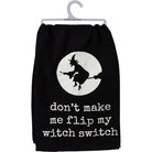 A black pet sweatshirt hanging on a white plastic hanger, featuring a white circular graphic of a witch riding a broomstick and the text 'don't make me flip my witch switch' in white lowercase letters.
