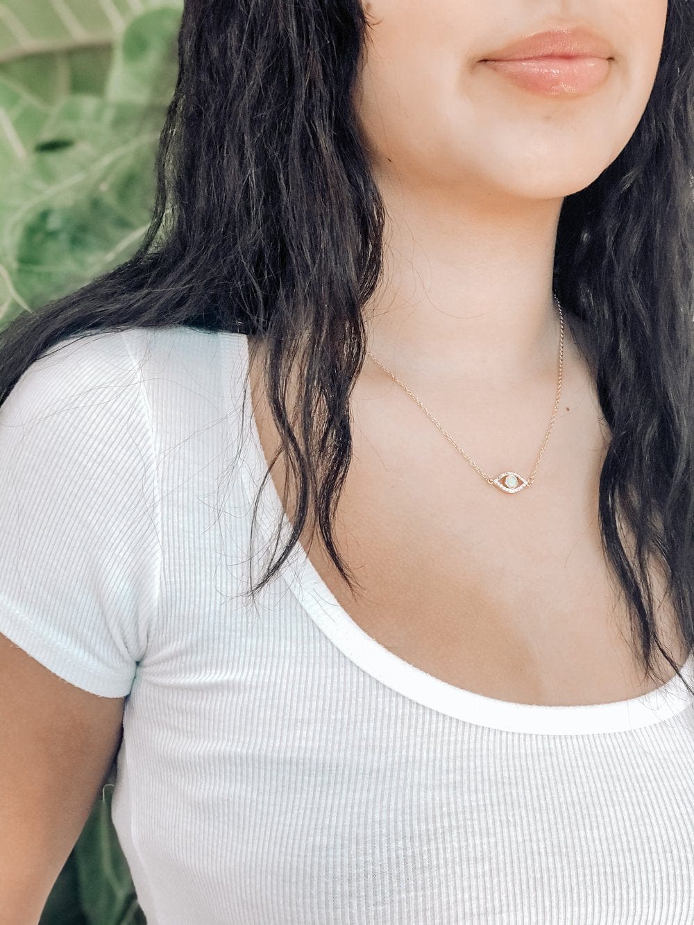 Young Woman With Dark Hair Wearing Pharauh's Evil Eye Necklace